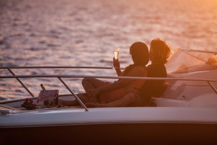 A couple drinking champagne onboard during a private boat tour in Bora Bora