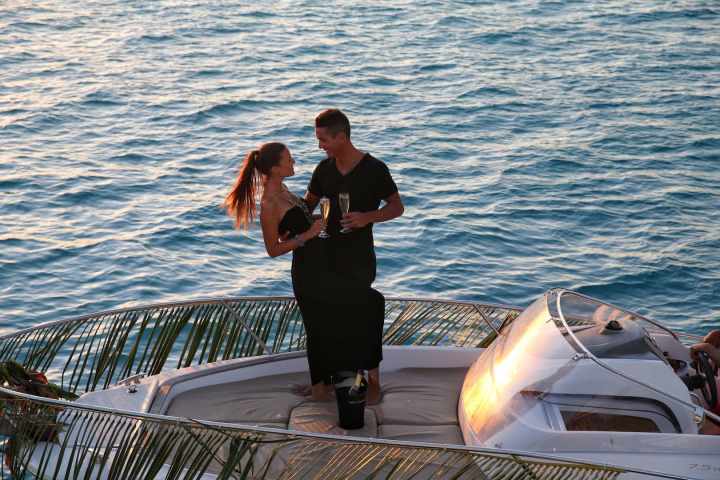 A couple drinking champagne onboard during a private boat tour in Bora Bora