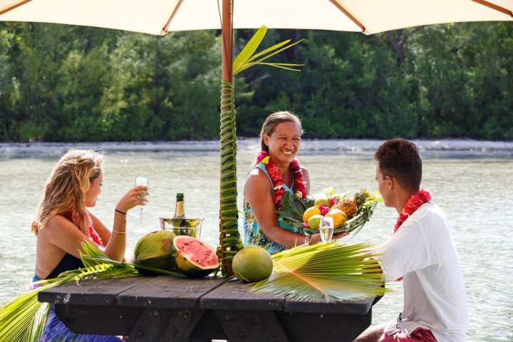 A couple having water lunch with champagne on a private island in Bora Bora