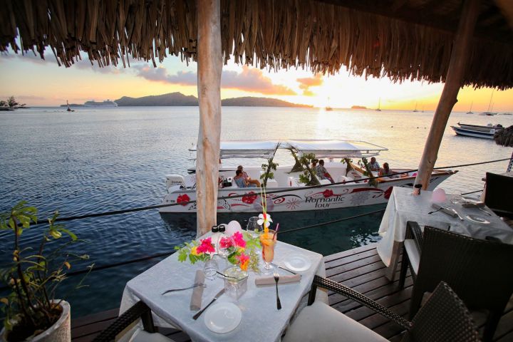 An outrigger canoe arriving at St James restaurant in Bora Bora